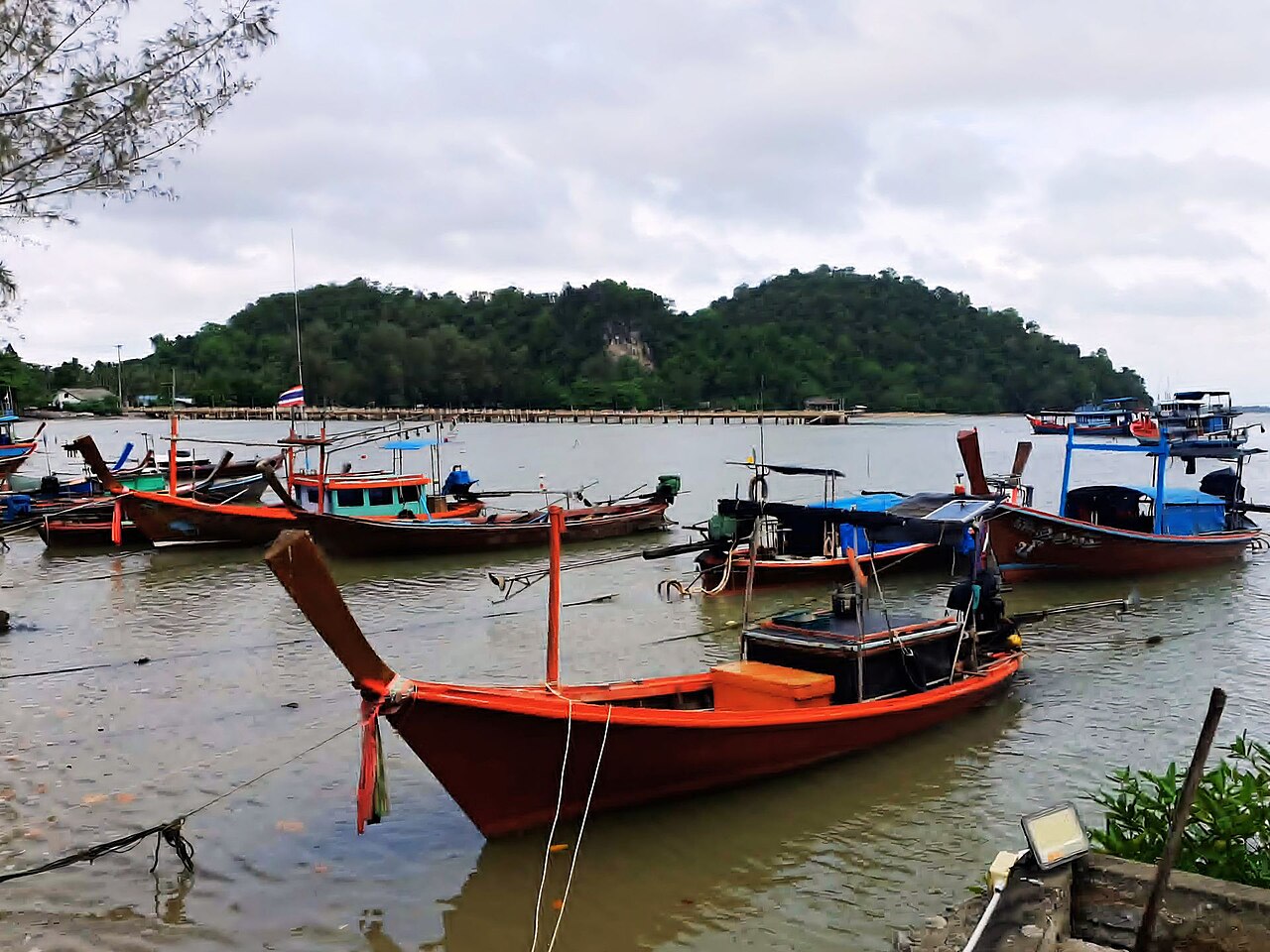 Longtail boats along a tropical coast
